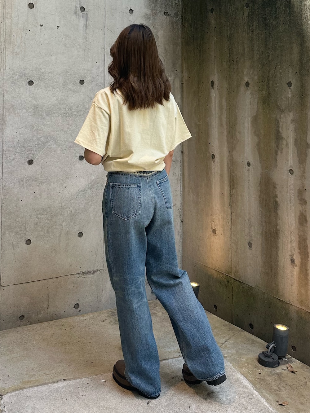 イエロー系のTシャツ/カットソー、ブルー系のデニムパンツ、ブラウン系のブーツを着用したレディースの春コーディネートの3枚目の写真