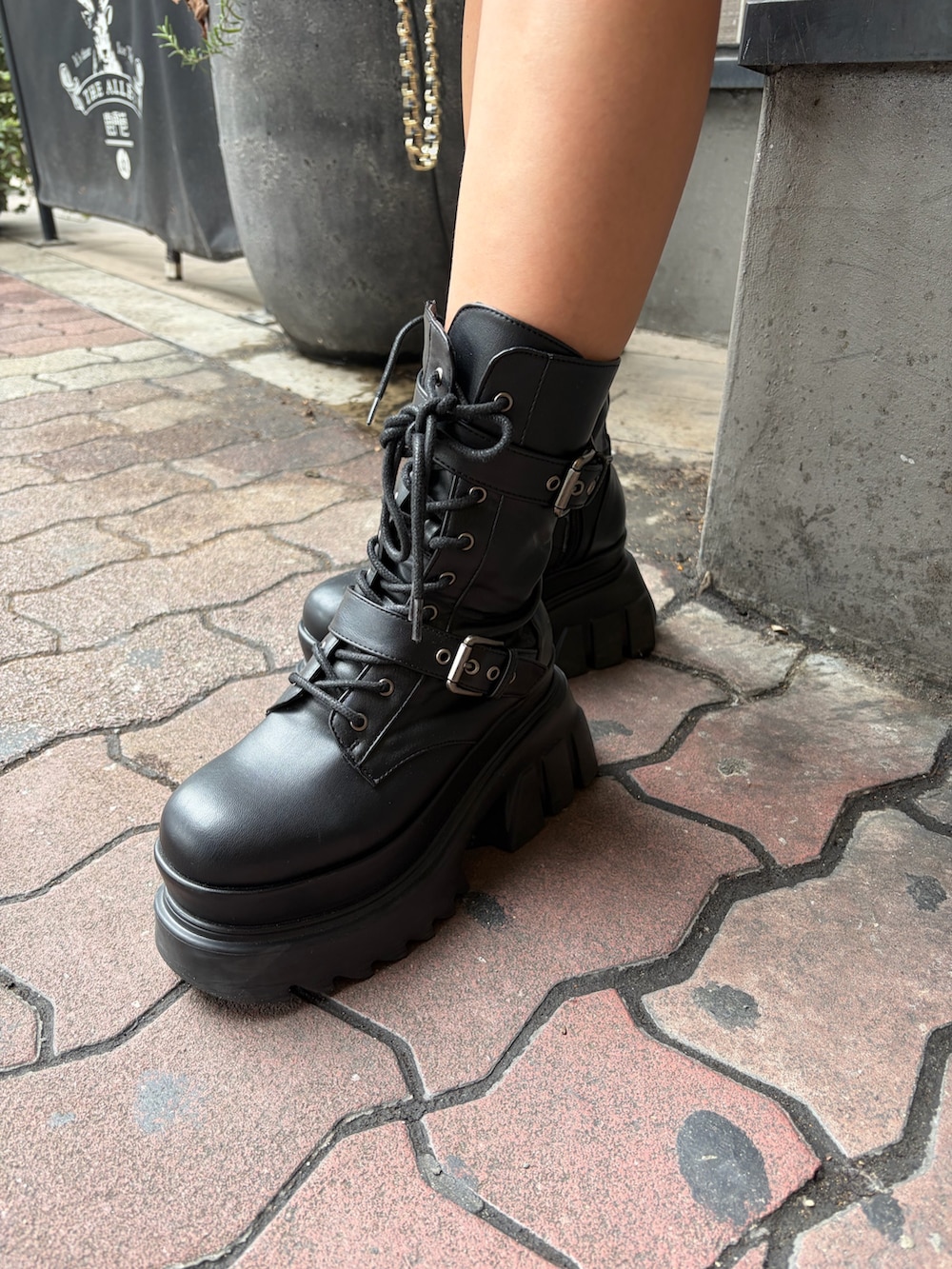 ブラック系のその他パンツ、ブラック系のブーツ、レッド系のニット/セーターを着用したレディースの秋コーディネートの6枚目の写真