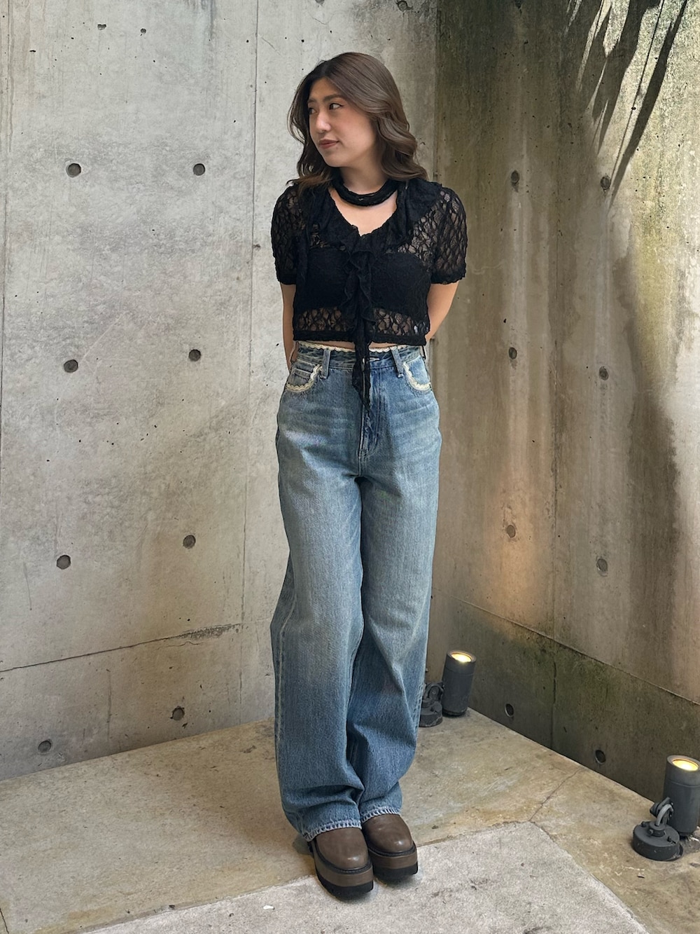 ブルー系のデニムパンツ、ブラウン系のブーツ、ブラック系のTシャツ/カットソーを着用したレディースの春コーディネートの2枚目の写真