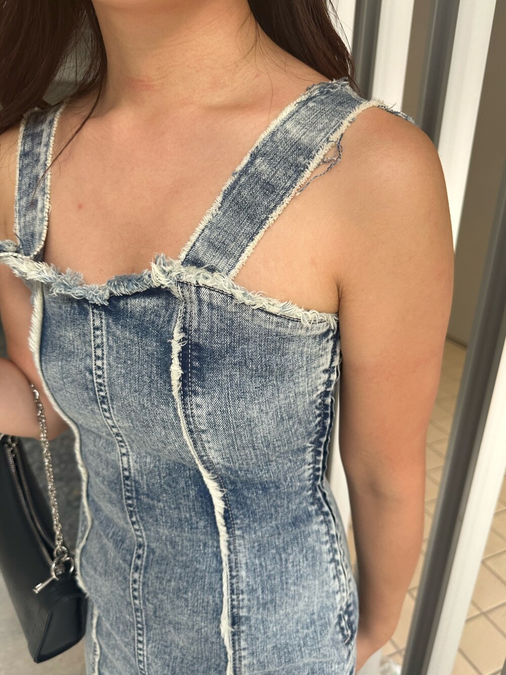 ブラック系のショルダーバッグ、ブラック系のブーツ、ブルー系のワンピースを着用したレディースの夏コーディネートの6枚目の写真