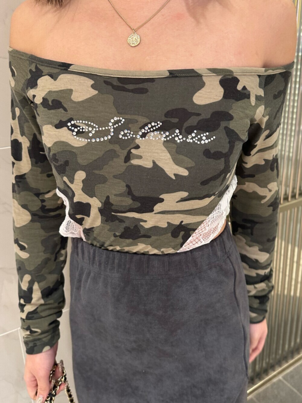 ブラック系のブーツ、ブラック系のスカート、ブラック系のショルダーバッグを着用したレディースの冬コーディネートの6枚目の写真