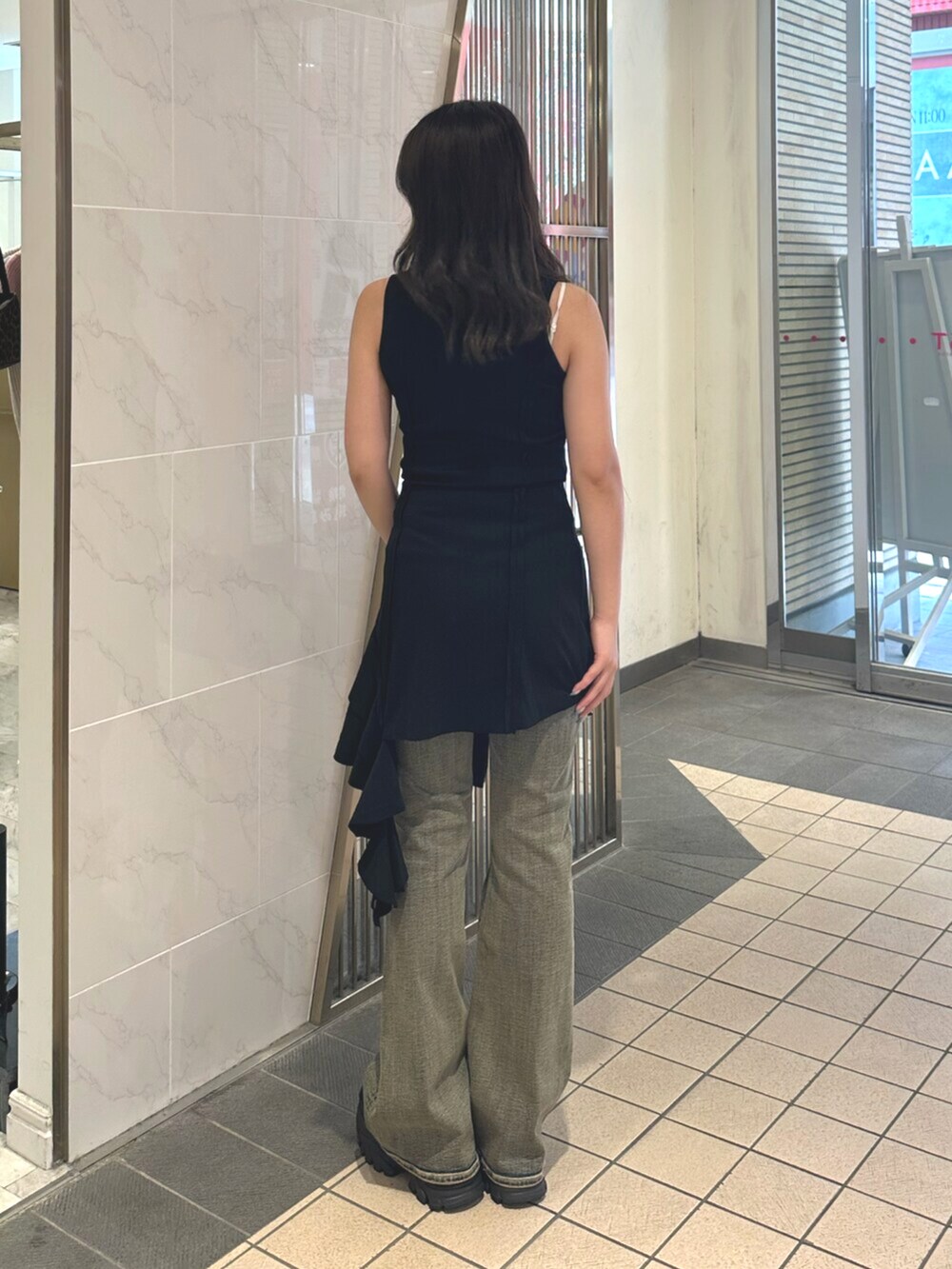 ブラック系のサンダル、ブルー系のデニムパンツ、ブラック系のワンピースを着用したレディースの夏コーディネートの3枚目の写真