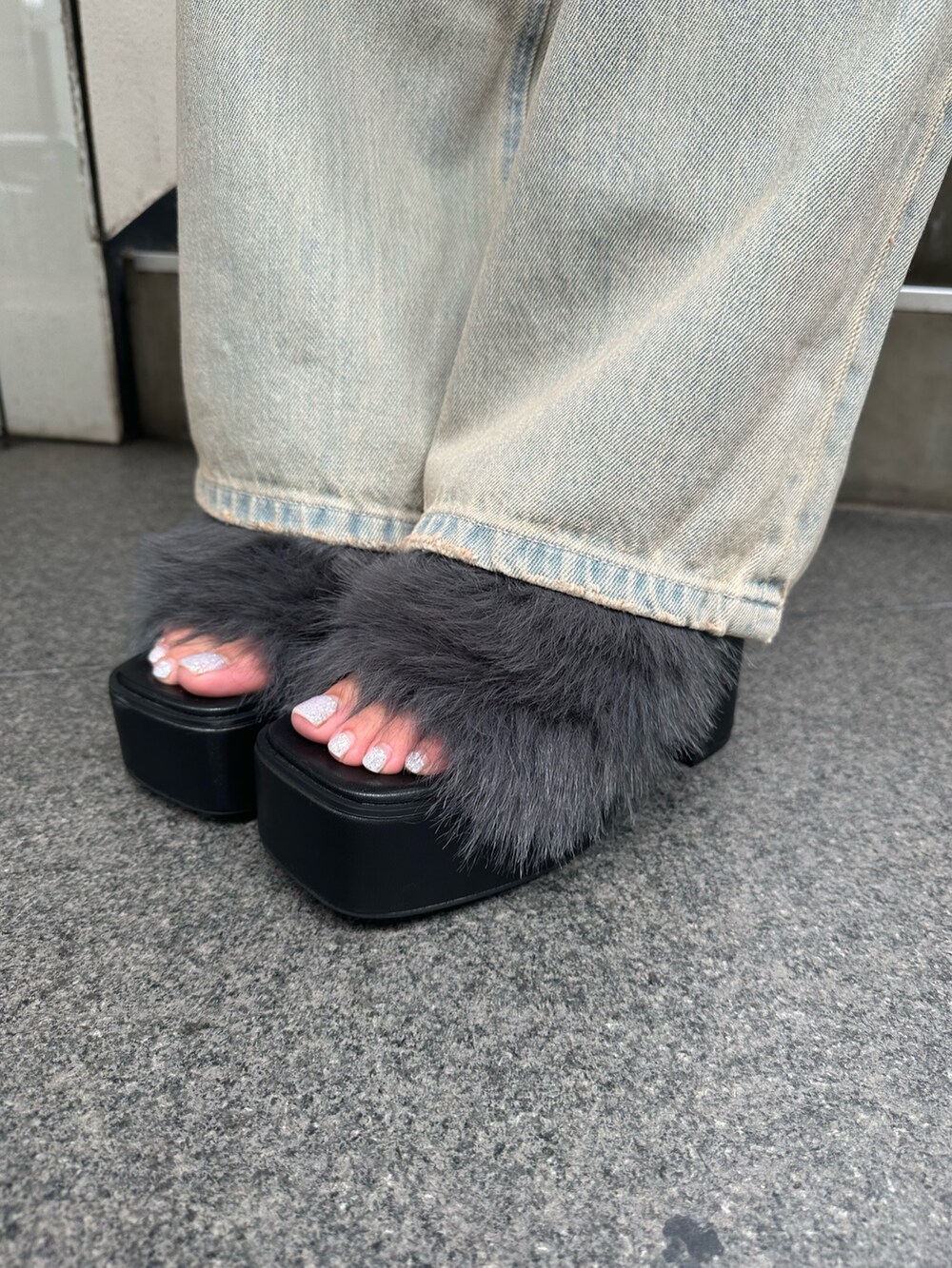 ブルー系のデニムパンツ、ブラック系のサンダル、ブラック系のTシャツ/カットソーを着用したレディースの秋コーディネートの8枚目の写真