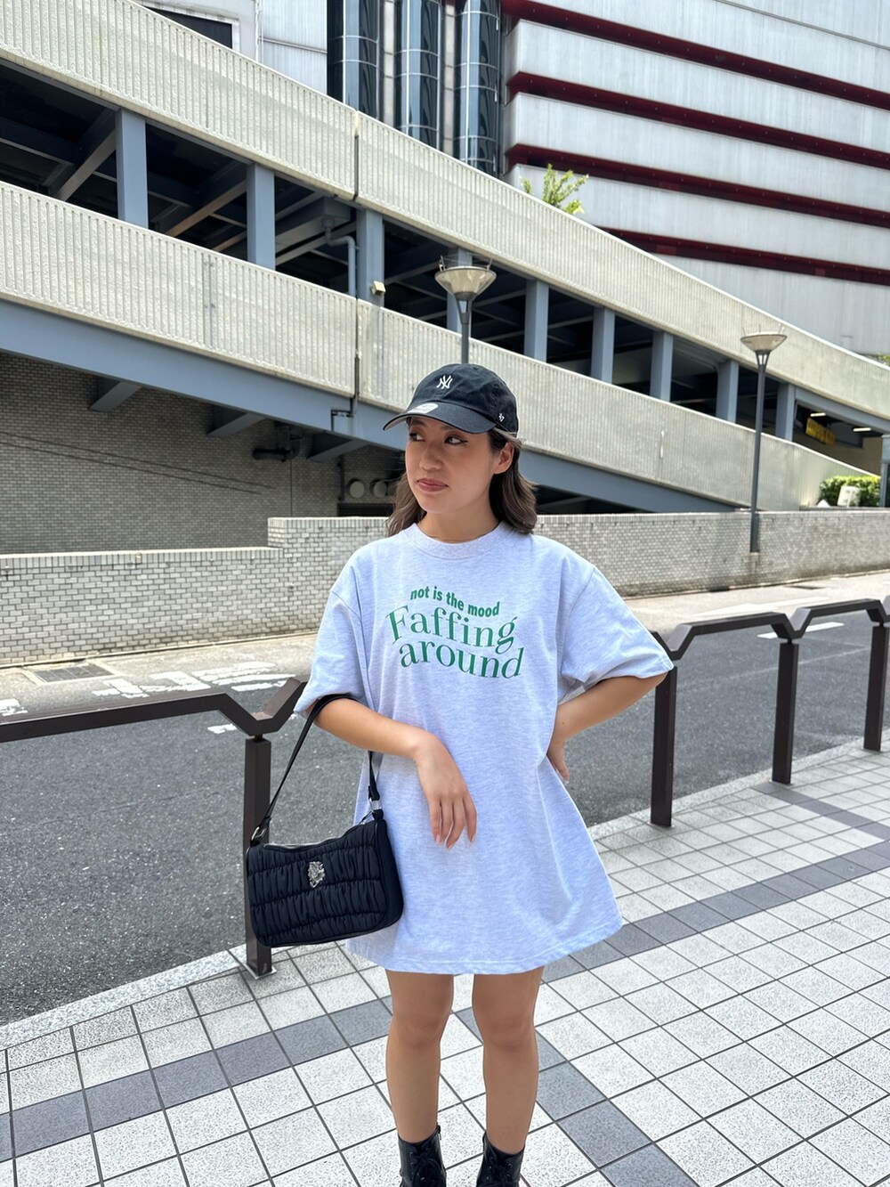 グレー系のTシャツ/カットソー、ブラック系のハンドバッグ、ブラック系のブーツを着用したレディースの夏コーディネートの4枚目の写真