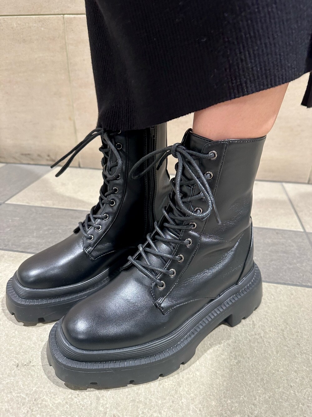 ブラック系のワンピース、ホワイト系のライダースジャケット、その他のショルダーバッグを着用したレディースの冬コーディネートの6枚目の写真