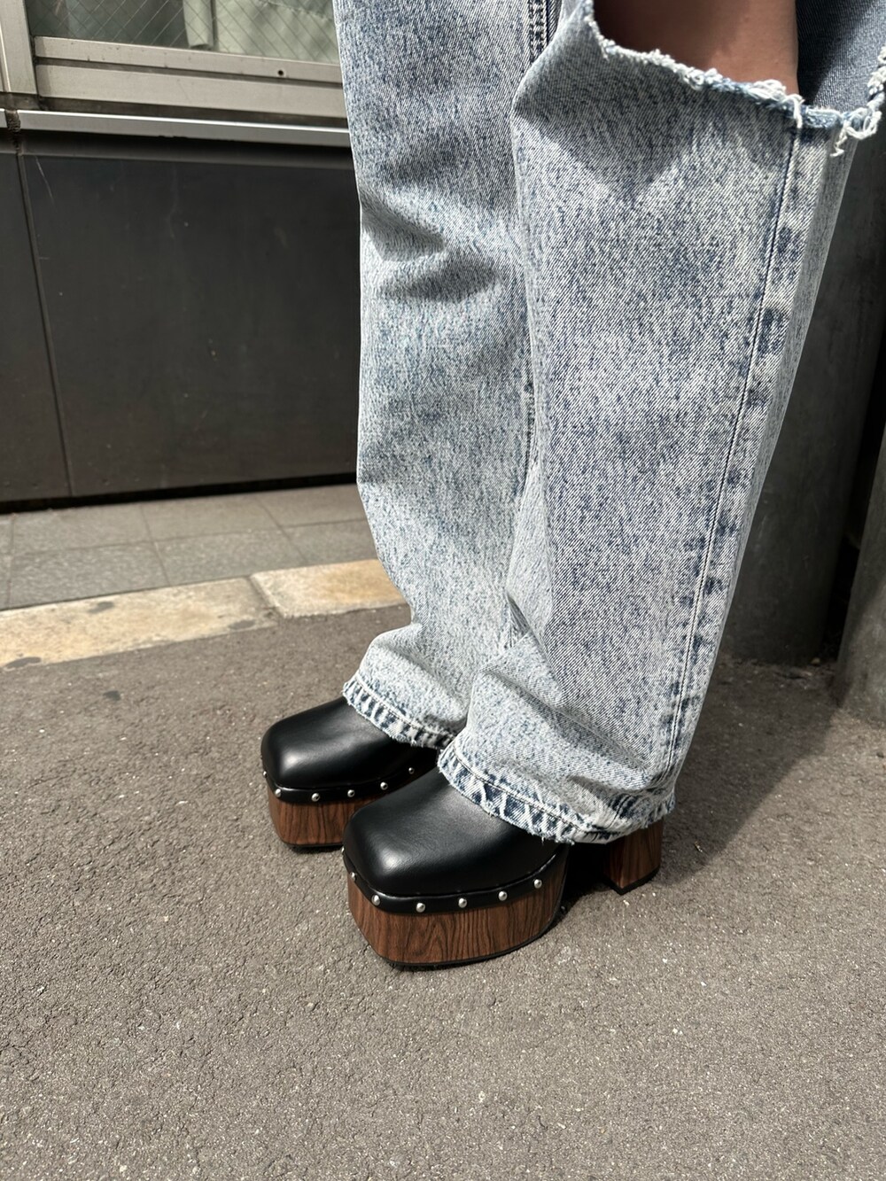 ブルー系のデニムパンツ、ブラック系のサンダル、オレンジ系のカーディガン/ボレロを着用したレディースの春コーディネートの7枚目の写真