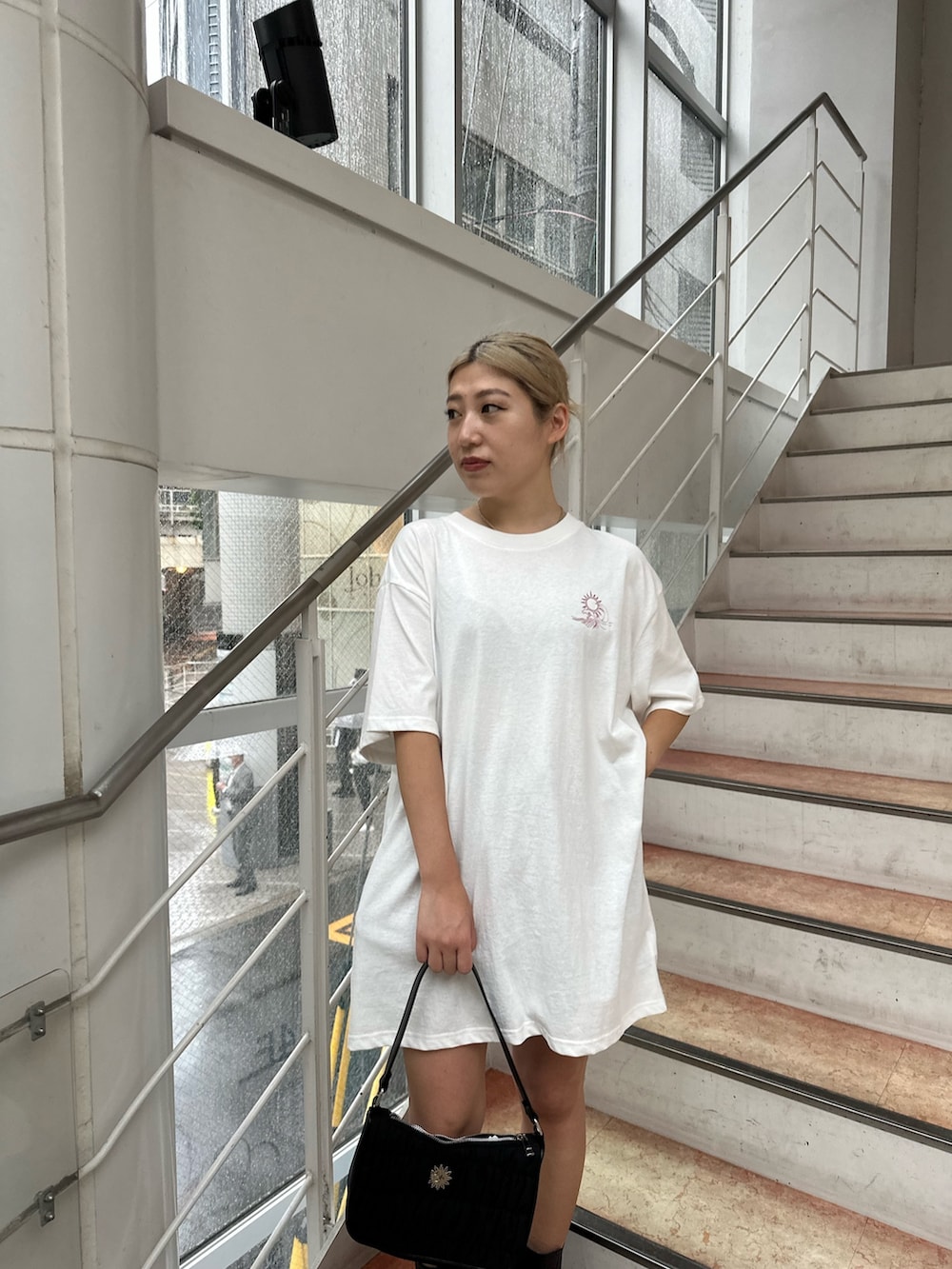 ホワイト系のTシャツ/カットソー、ブラック系のブーツ、ブラック系のハンドバッグを着用したレディースの夏コーディネートの4枚目の写真