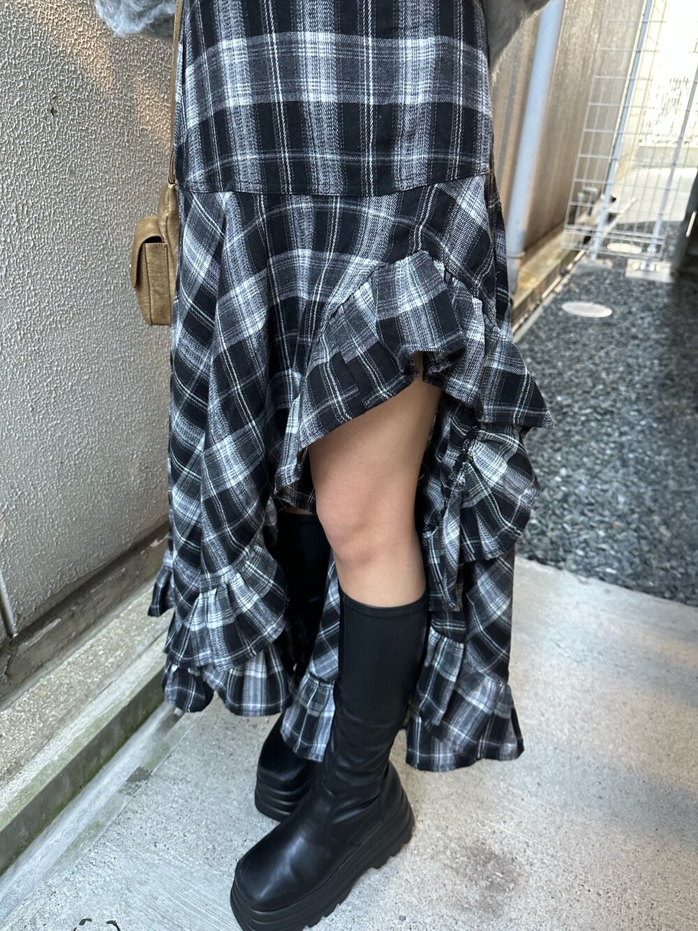 グレー系のニット/セーター、ブラック系のスカート、ブラック系のブーツを着用したレディースの冬コーディネートの7枚目の写真