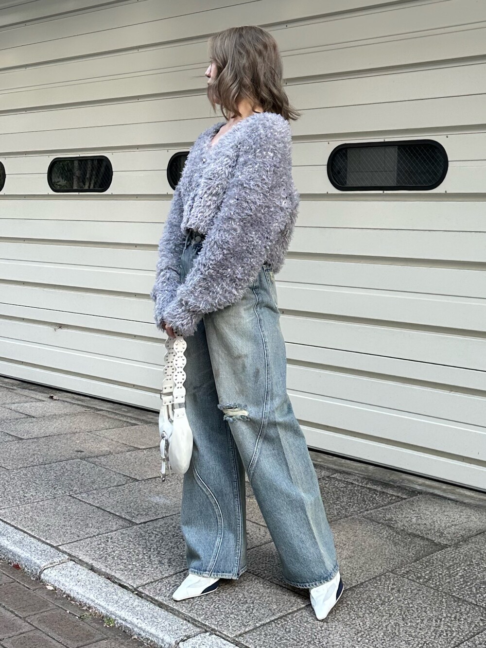 グレー系のカーディガン/ボレロ、ブルー系のデニムパンツを着用したレディースの冬コーディネートの2枚目の写真