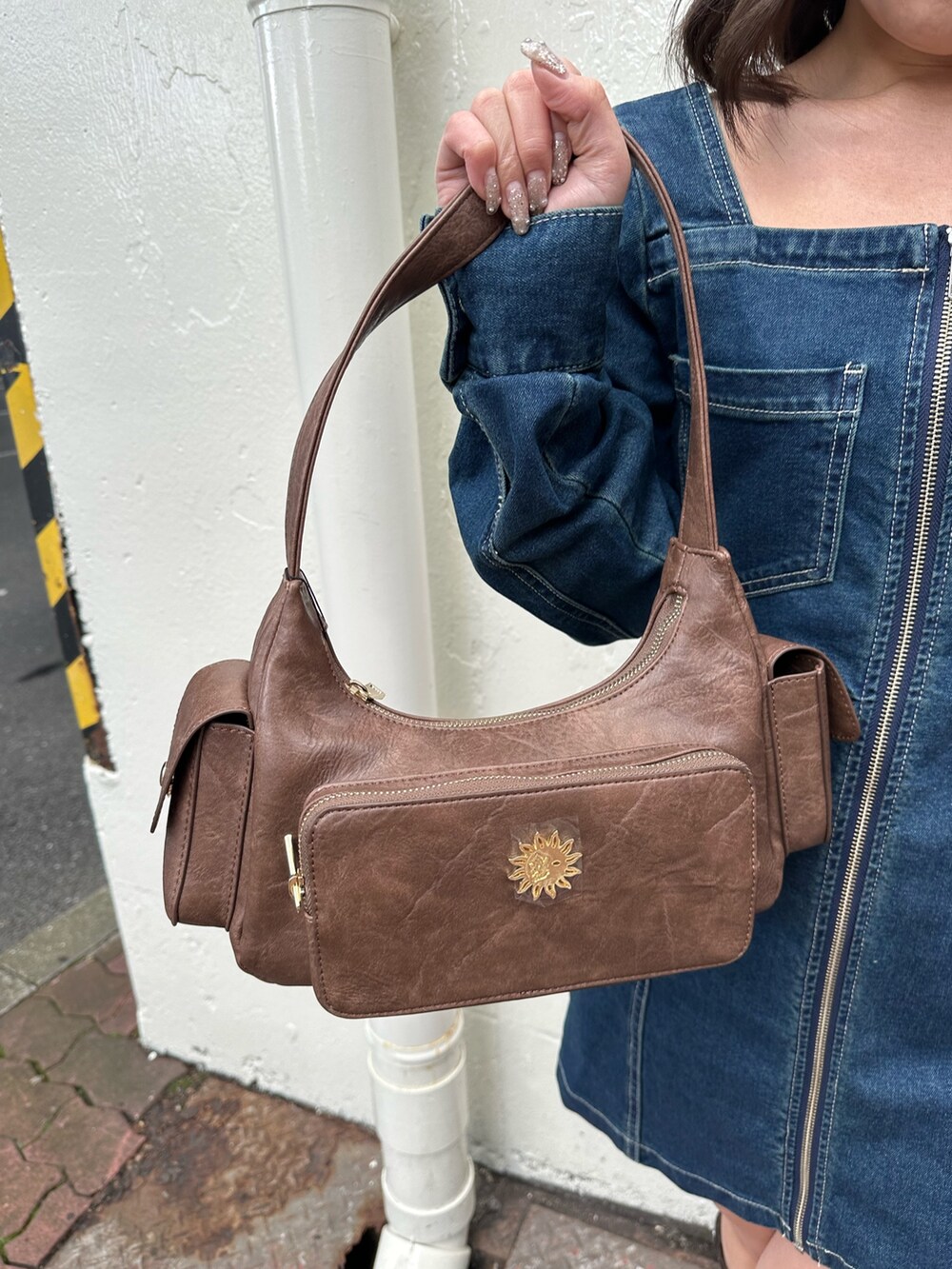 ブラウン系のブーツ、ブルー系のワンピース、ブラウン系のハンドバッグを着用したレディースの冬コーディネートの6枚目の写真