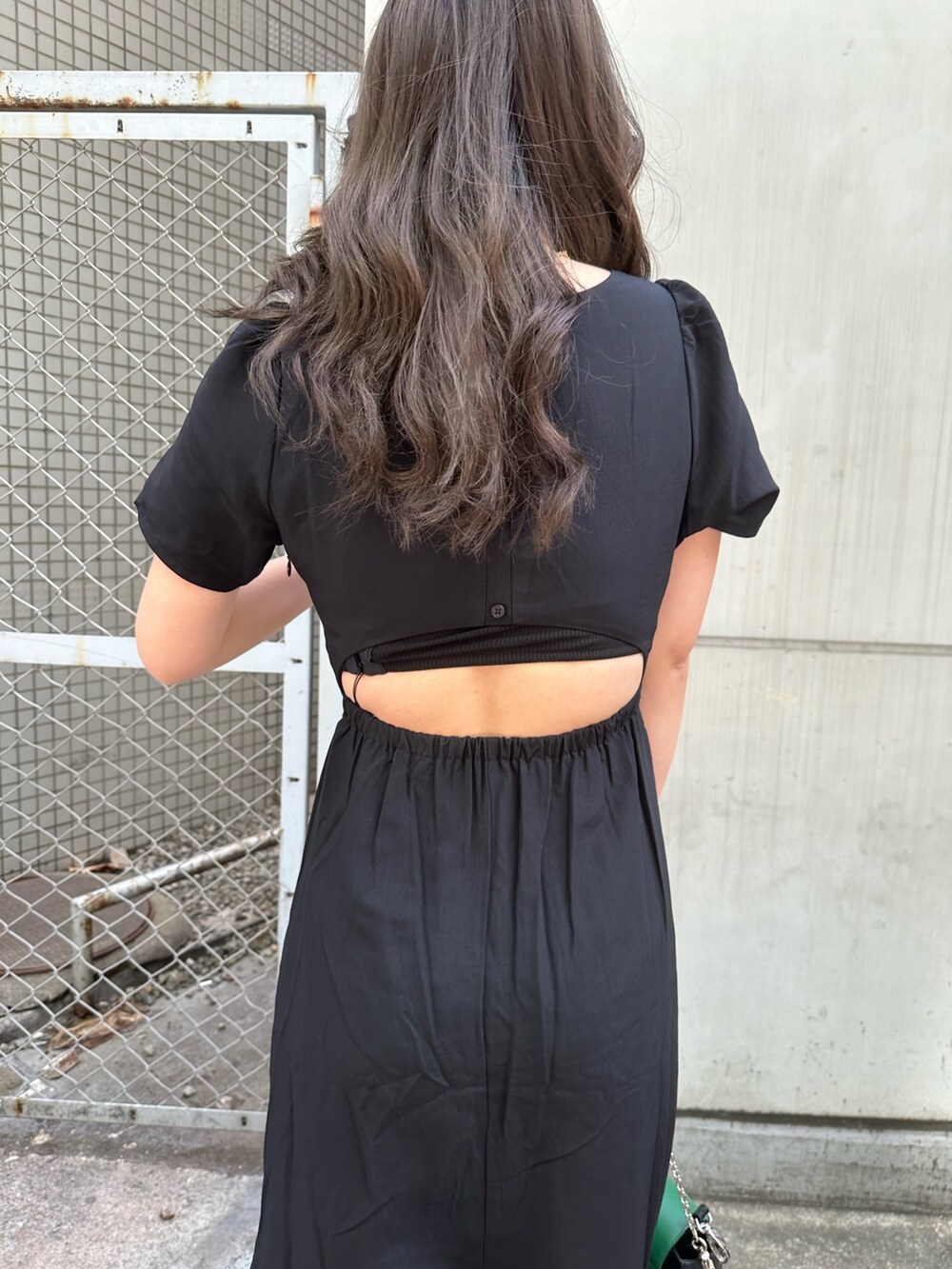 ブラック系のワンピース、ホワイト系のブーツ、ブラック系のショルダーバッグを着用したレディースの春コーディネートの5枚目の写真