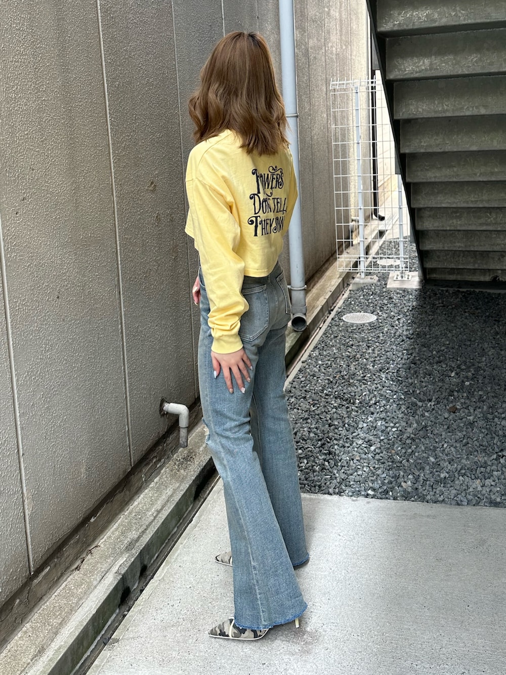 イエロー系のTシャツ/カットソー、ブルー系のデニムパンツ、ブラック系のショルダーバッグを着用したレディースの春コーディネートの2枚目の写真