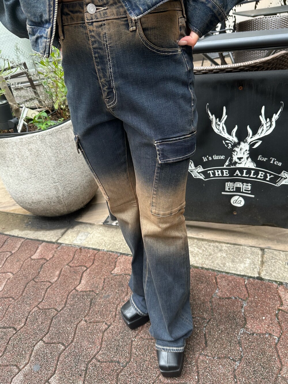 ブルー系のデニムパンツ、ブラック系のブーツ、ブラウン系のニット/セーターを着用したレディースの秋コーディネートの5枚目の写真