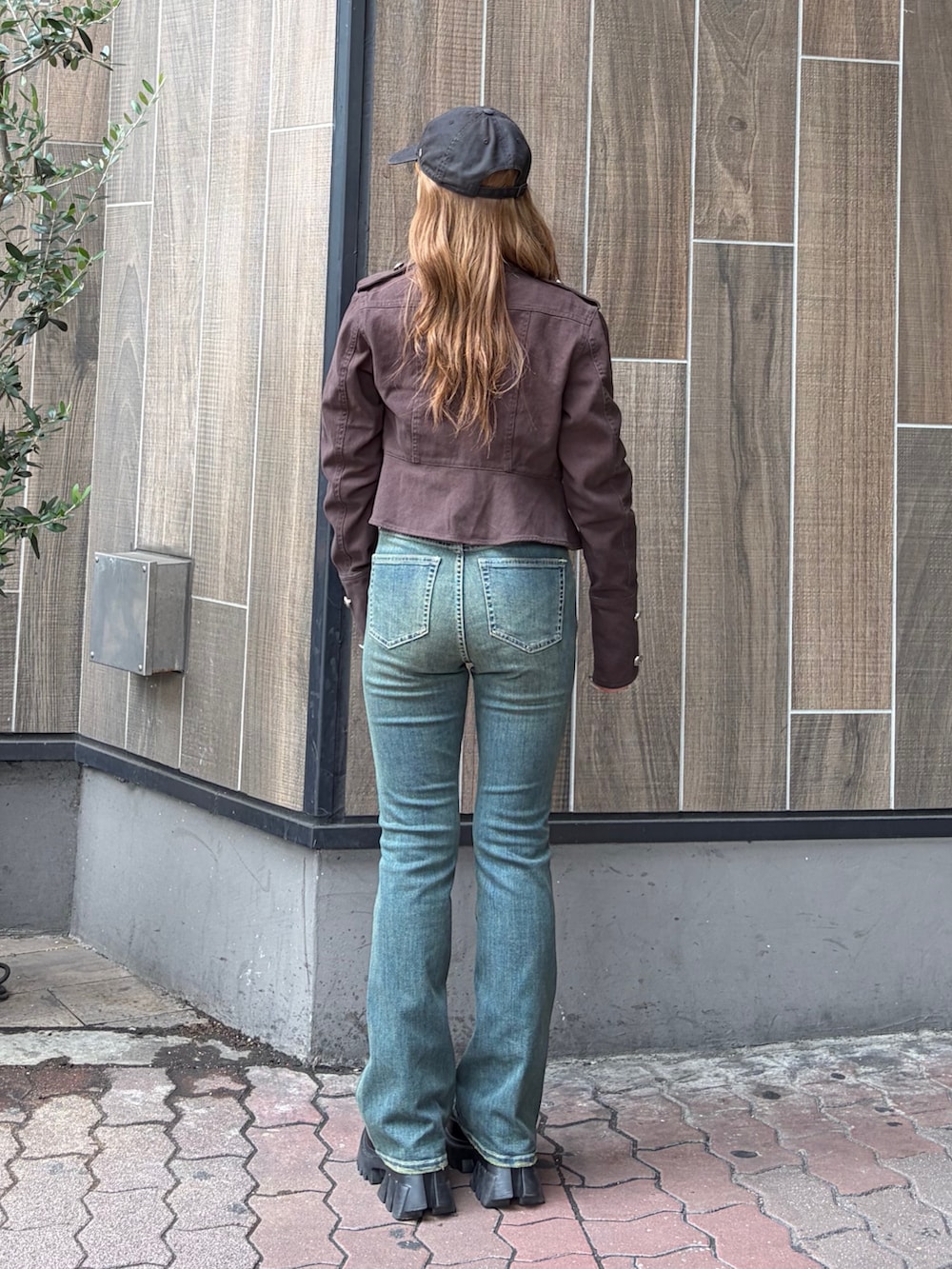ブルー系のデニムパンツ、ブラック系のブーツ、ブラック系のミリタリージャケットを着用したレディースの秋コーディネートの3枚目の写真