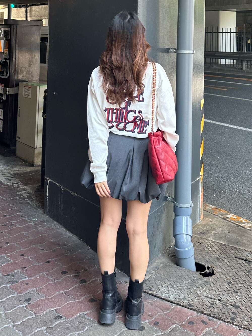 ホワイト系のTシャツ/カットソー、グレー系のスカート、ブラック系のブーツを着用したレディースの秋コーディネートの3枚目の写真