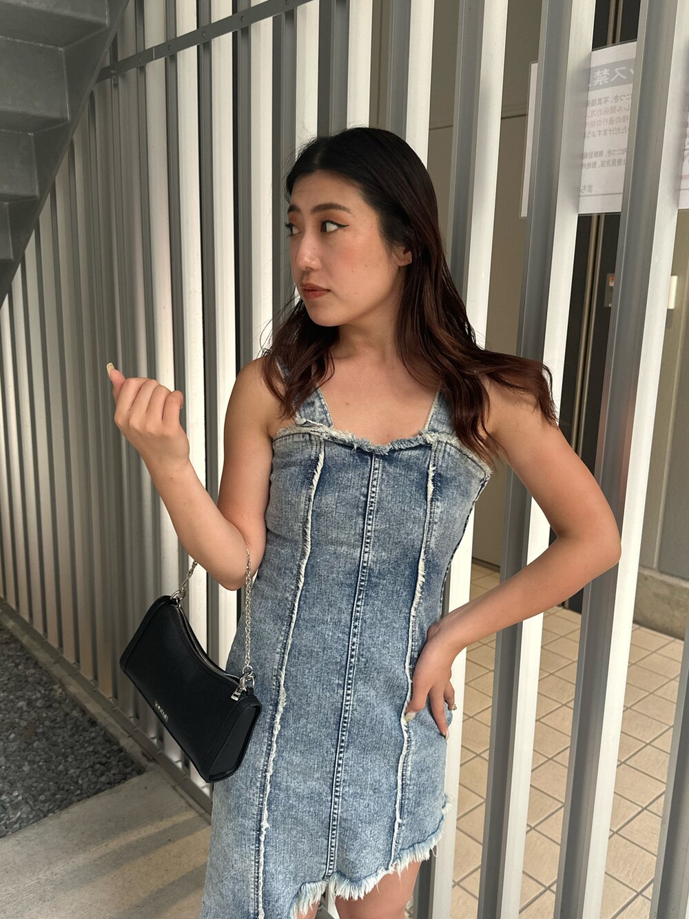 ブラック系のショルダーバッグ、ブラック系のブーツ、ブルー系のワンピースを着用したレディースの夏コーディネートの5枚目の写真