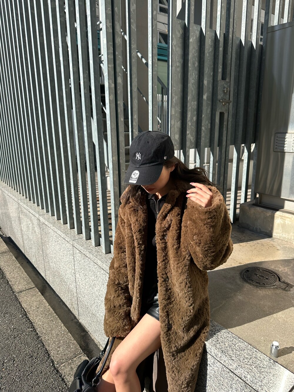 ブラック系のブーツ、ブラック系のハンドバッグ、ブラック系のその他パンツを着用したレディースの冬コーディネートの5枚目の写真