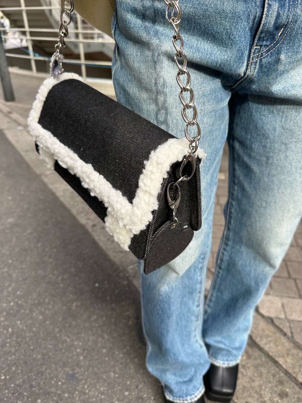 イエロー系のニット/セーター、ブルー系のデニムパンツ、ブラック系のショルダーバッグを着用したレディースの冬コーディネートの7枚目の写真