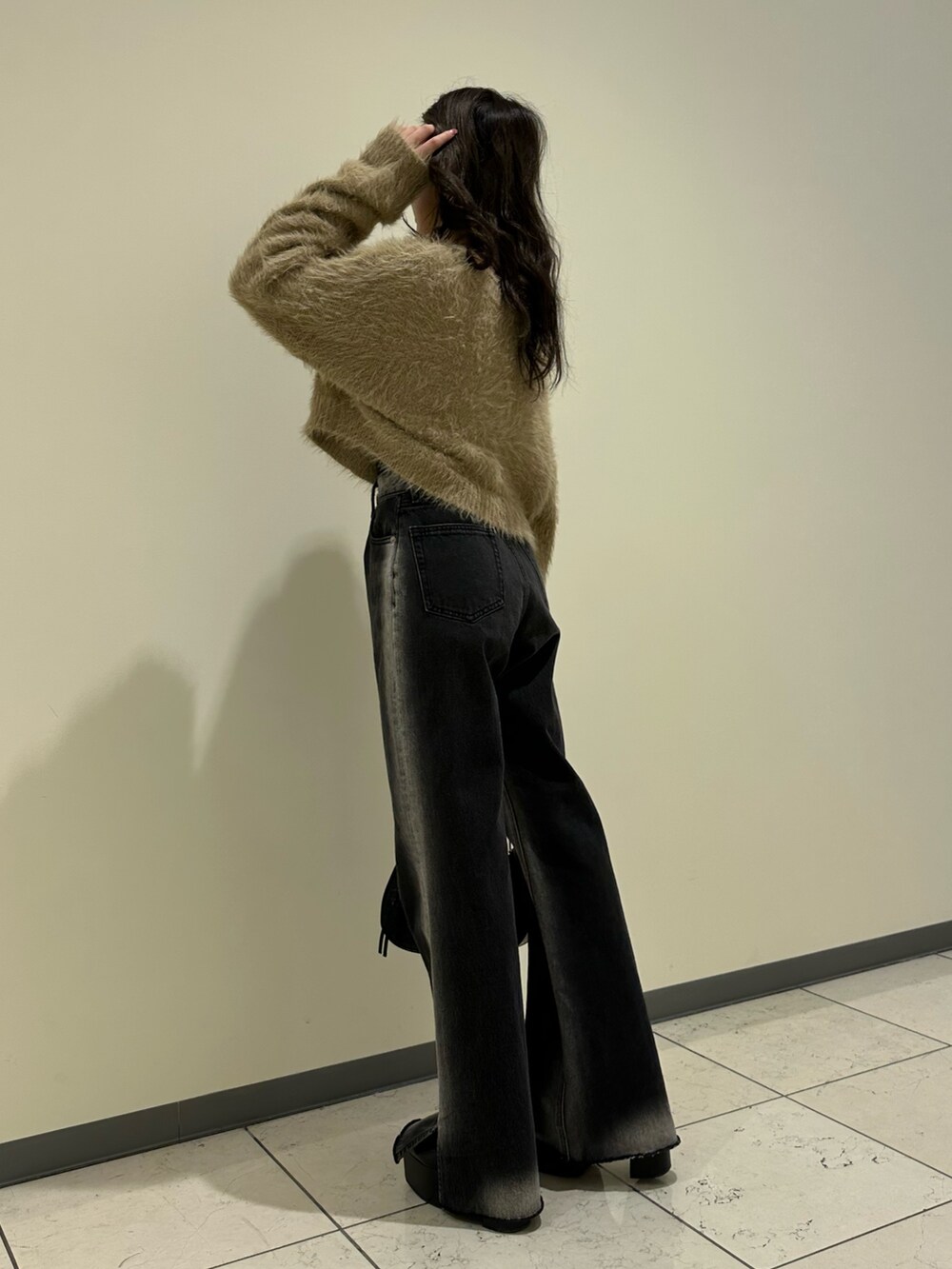 ベージュ系のニット/セーター、ブラック系のショルダーバッグ、ブラック系のブーツを着用したレディースの冬コーディネートの2枚目の写真