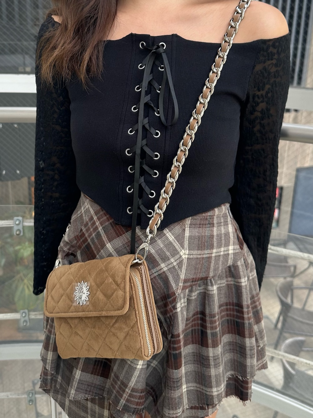 ベージュ系のハンドバッグ、ブラック系のTシャツ/カットソー、ブラック系のブーツを着用したレディースの秋コーディネートの5枚目の写真