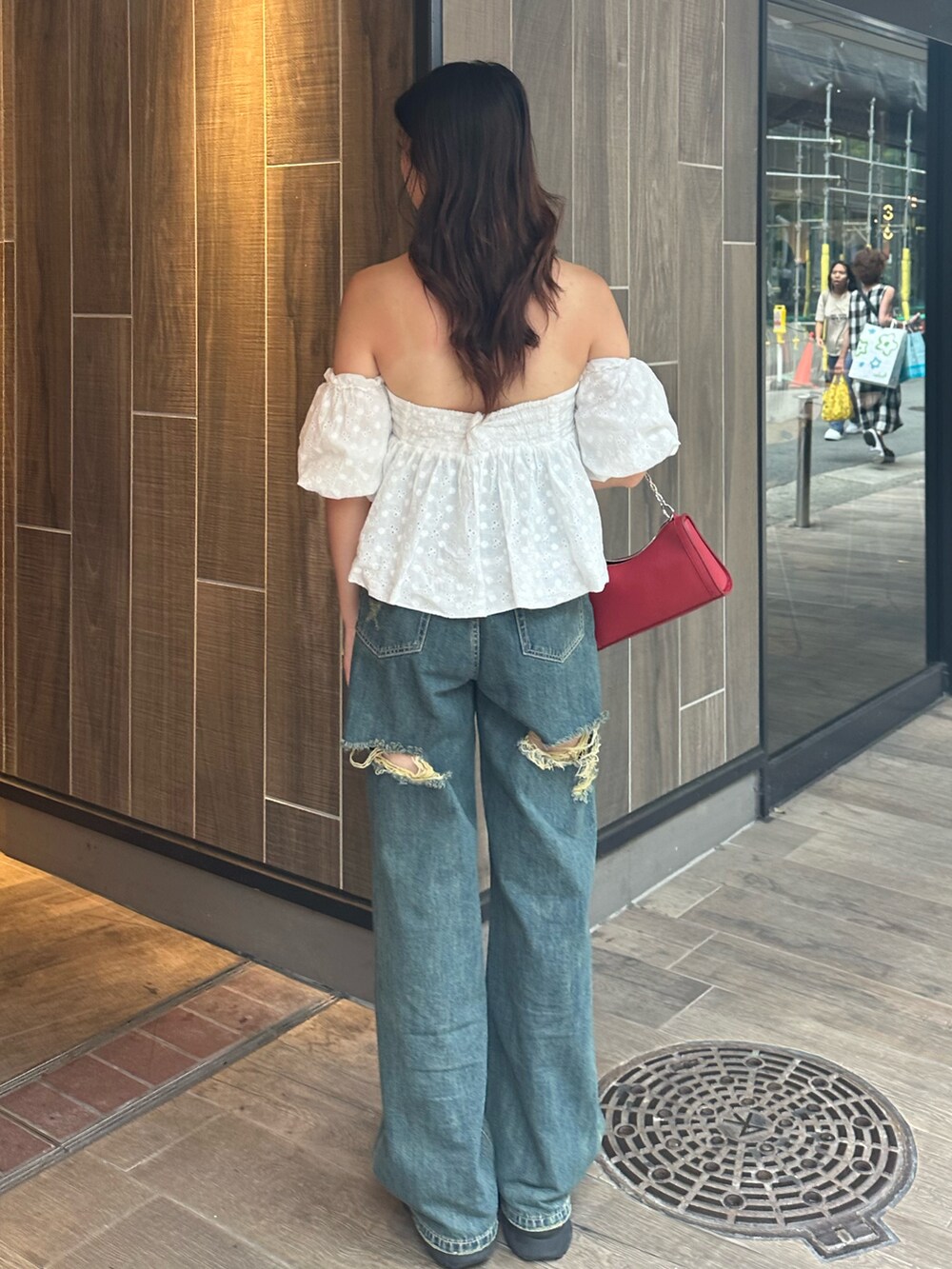 ブルー系のデニムパンツ、ホワイト系のシャツ/ブラウス、レッド系のショルダーバッグを着用したレディースの夏コーディネートの4枚目の写真