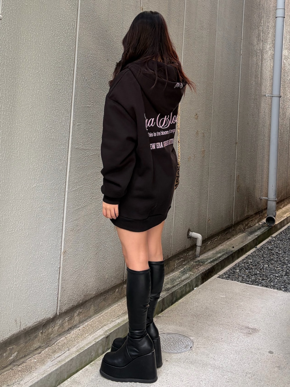 ブラック系のパーカー、ブラック系のブーツ、ブラック系のショルダーバッグを着用したレディースの秋コーディネートの2枚目の写真