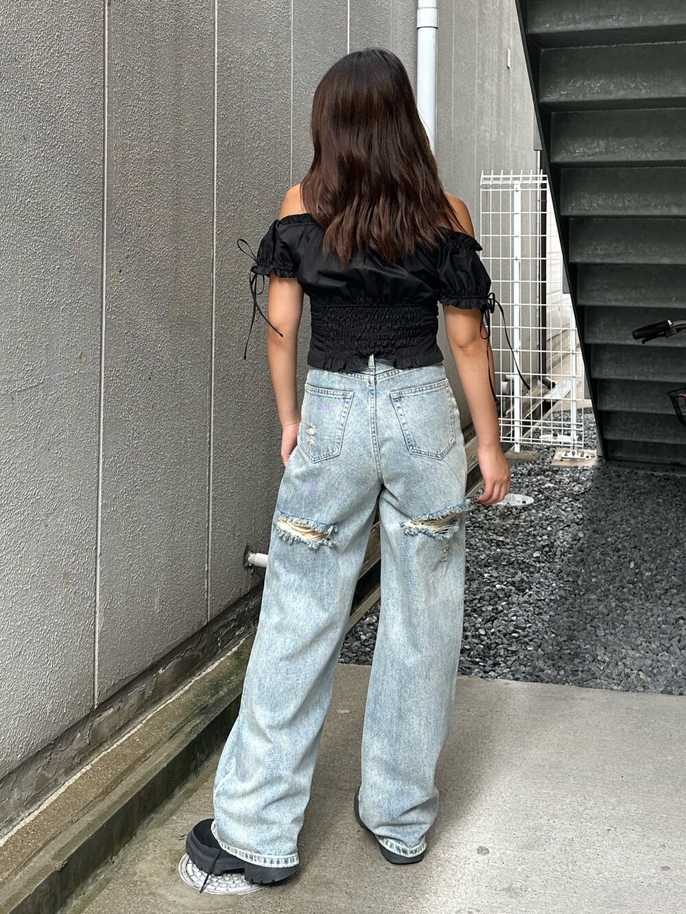 ブルー系のデニムパンツ、ブラック系のシャツ/ブラウス、ブラック系のブーツを着用したレディースの夏コーディネートの3枚目の写真