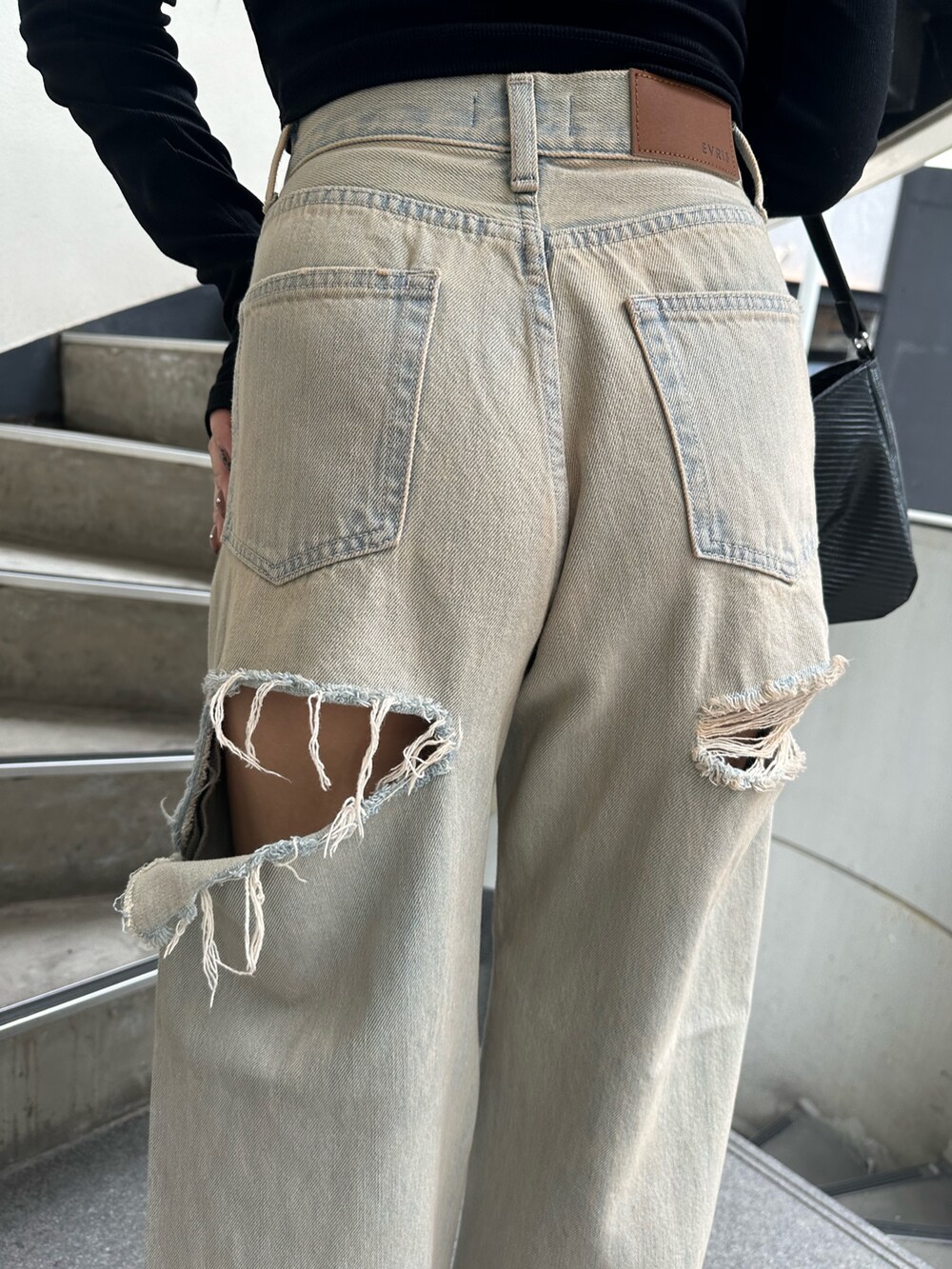 ブルー系のデニムパンツ、ブラック系のサンダル、ブラック系のTシャツ/カットソーを着用したレディースの秋コーディネートの6枚目の写真