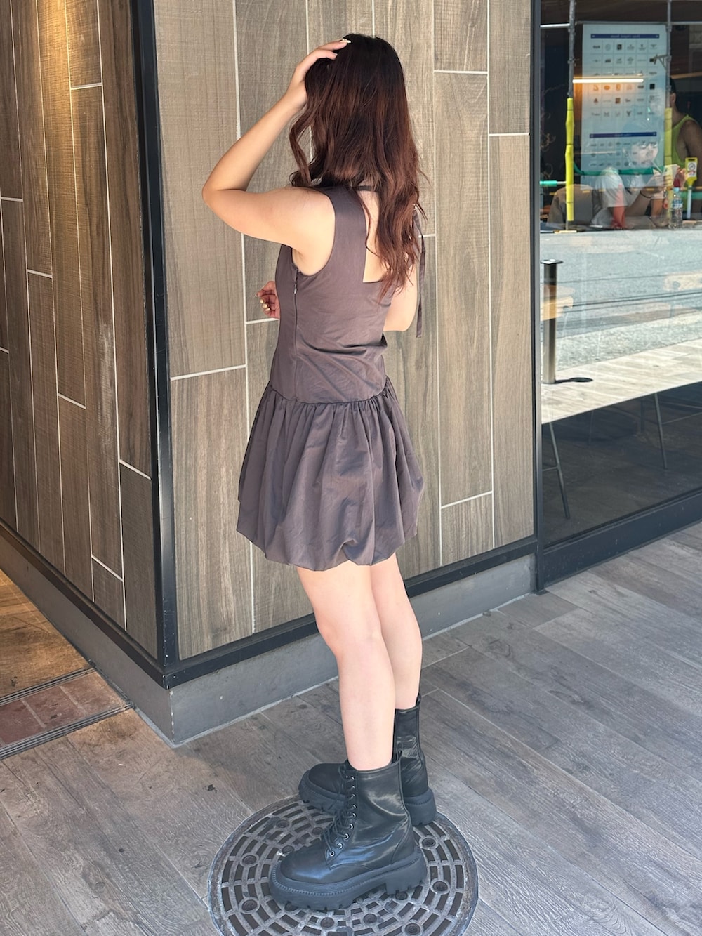 グレー系のワンピース、ホワイト系のショルダーバッグ、ブラック系のブーツを着用したレディースの夏コーディネートの3枚目の写真