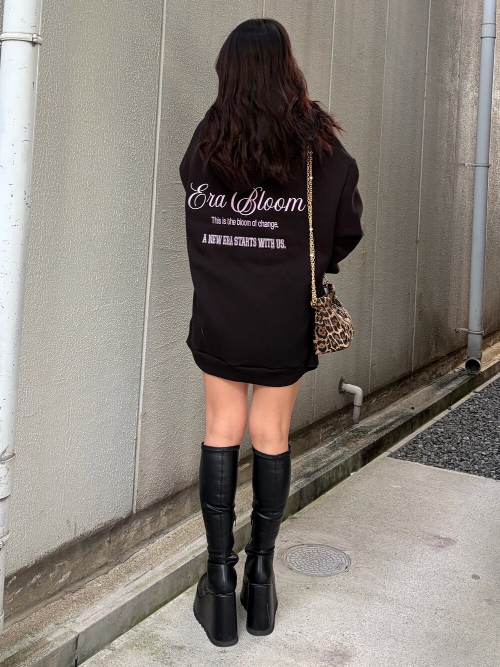 ブラック系のパーカー、ブラック系のブーツ、ブラック系のショルダーバッグを着用したレディースの秋コーディネートの3枚目の写真