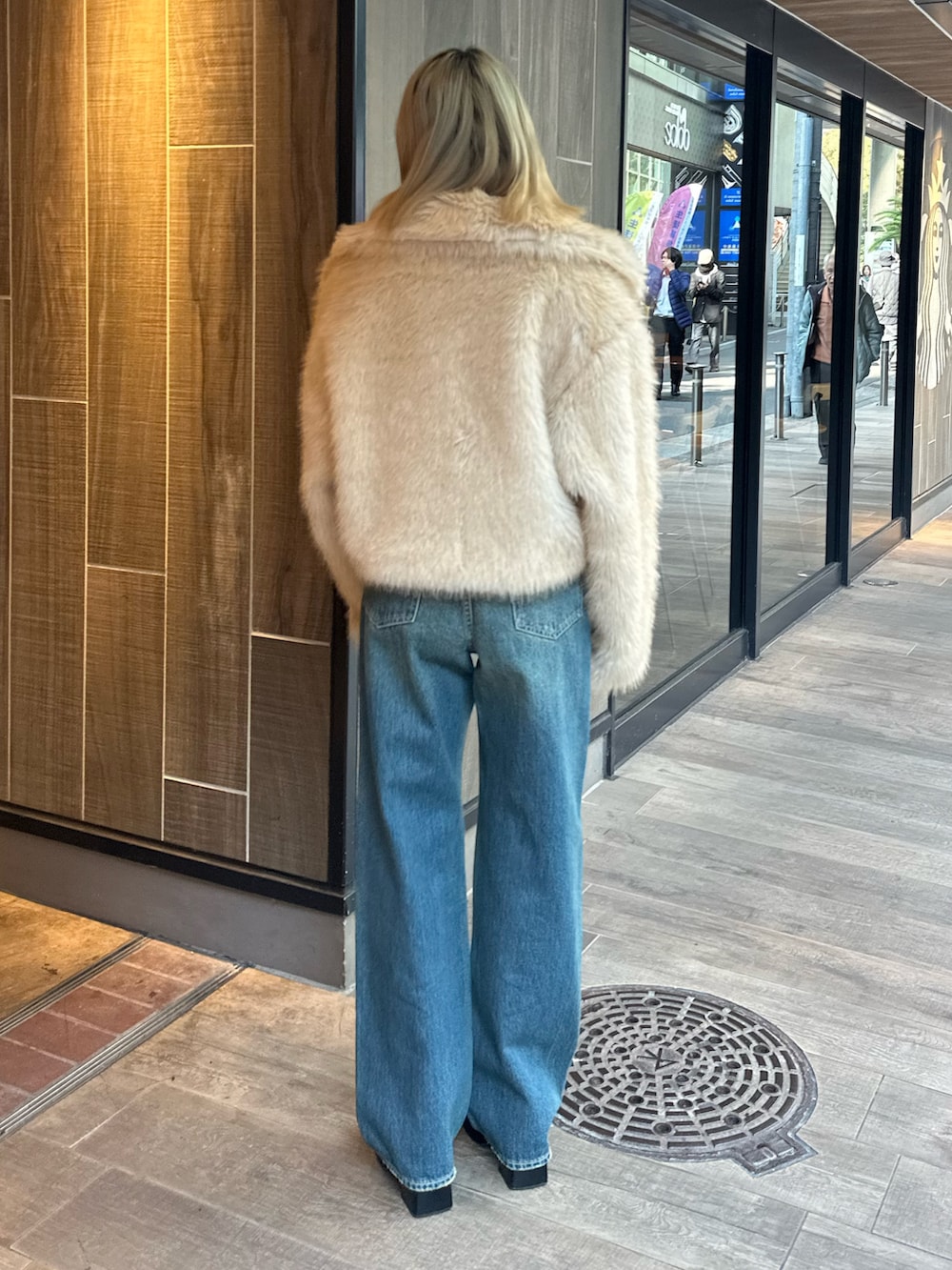 ベージュ系のブルゾン、その他のブーツ、ブルー系のデニムパンツを着用したレディースの冬コーディネートの4枚目の写真