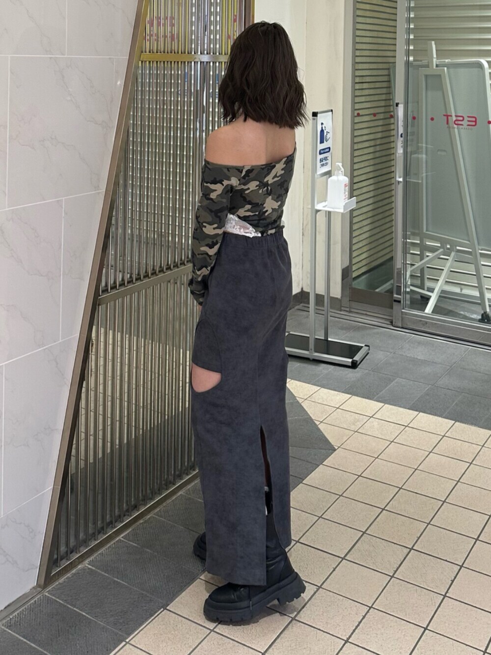 ブラック系のブーツ、ブラック系のスカート、ブラック系のショルダーバッグを着用したレディースの冬コーディネートの2枚目の写真