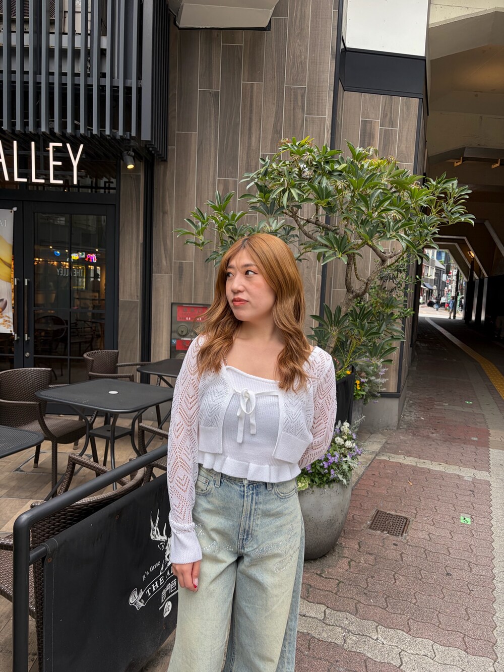 ブルー系のデニムパンツ、ホワイト系のカーディガン/ボレロを着用したレディースの春コーディネートの4枚目の写真