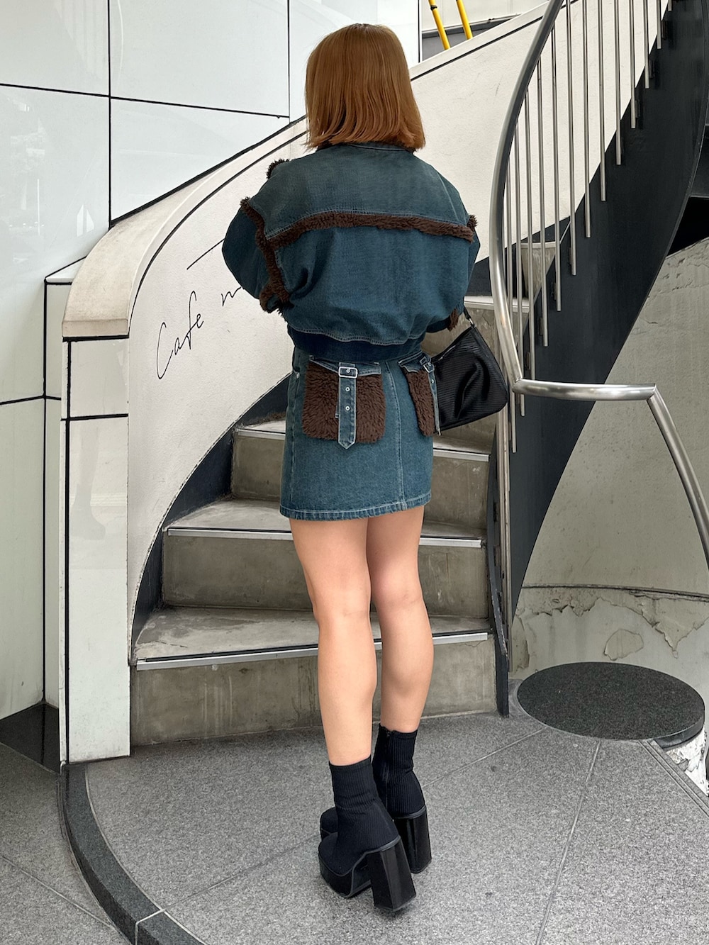 ブルー系のブルゾン、ブルー系のデニムスカート、その他のブーツを着用したレディースの秋コーディネートの2枚目の写真