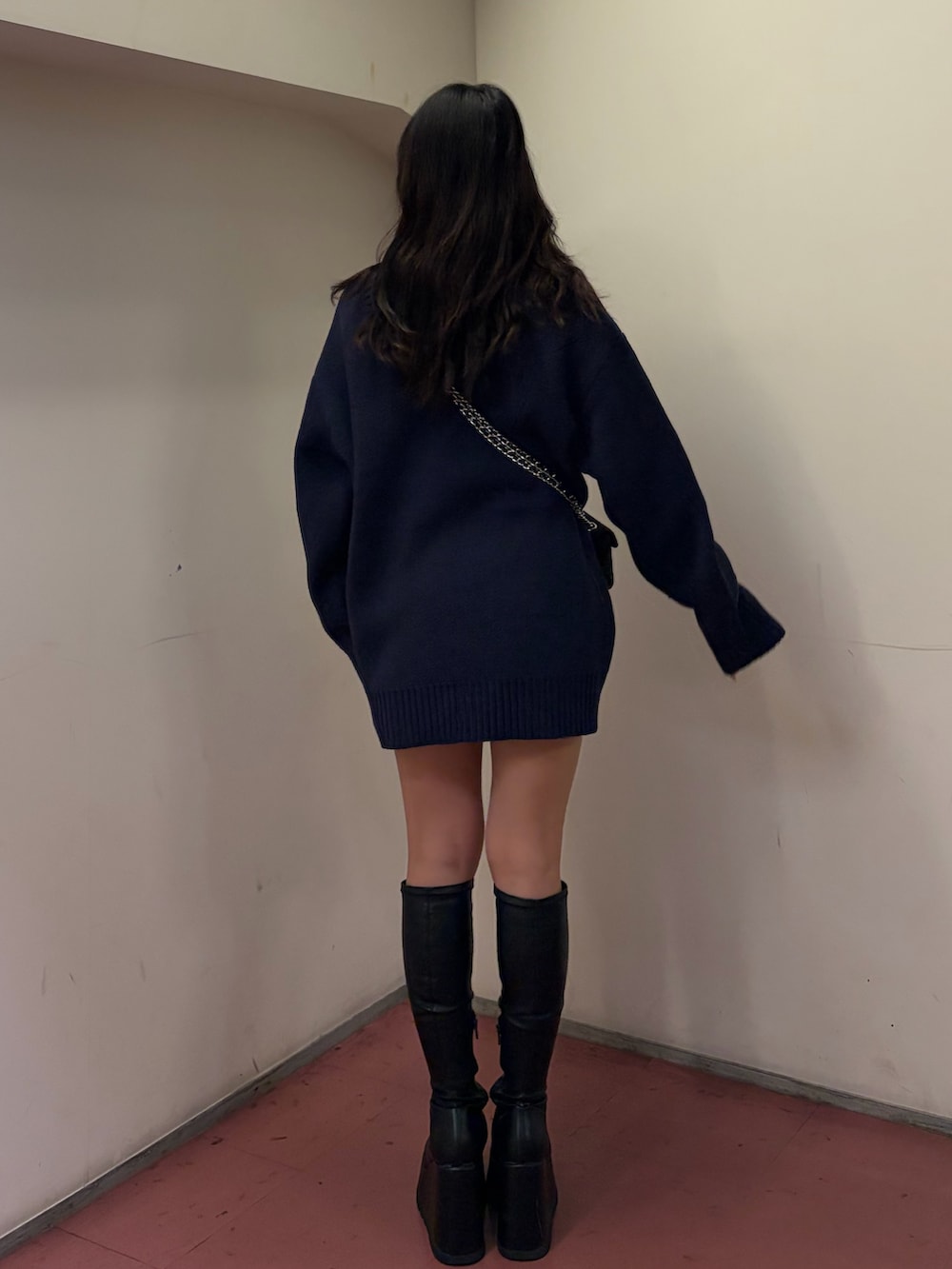 ブラック系のブーツ、ブラック系のショルダーバッグ、ブルー系のニット/セーターを着用したレディースの冬コーディネートの3枚目の写真