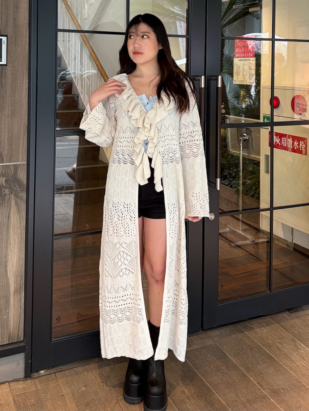 ブラック系のその他パンツ、ブラック系のブーツ、ホワイト系のカーディガン/ボレロを着用したレディースの春コーディネートの2枚目の写真