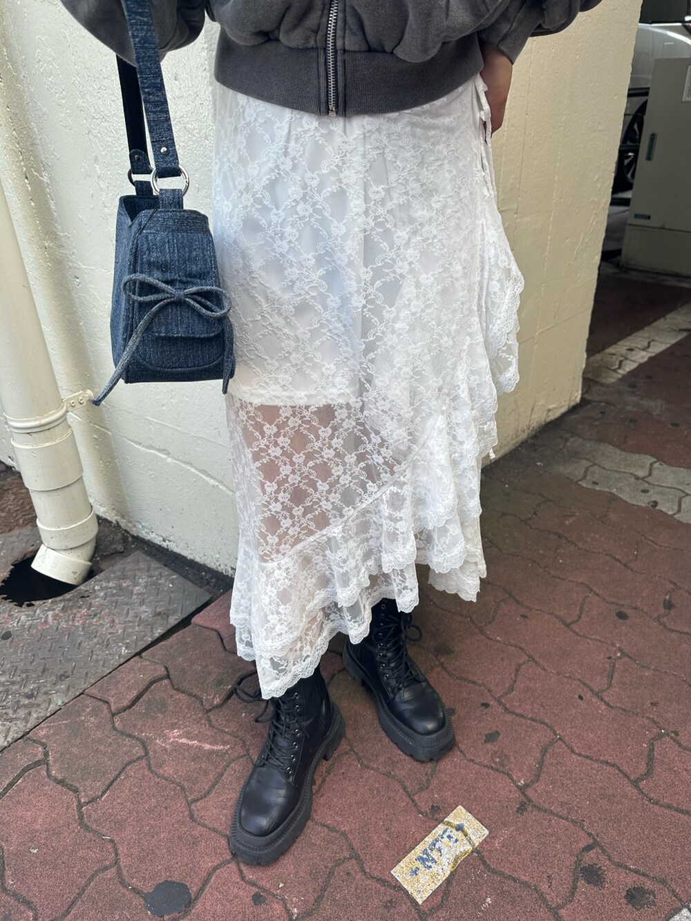 ホワイト系のスカート、グレー系のスウェット、ブラック系のブーツを着用したレディースの秋コーディネートの9枚目の写真