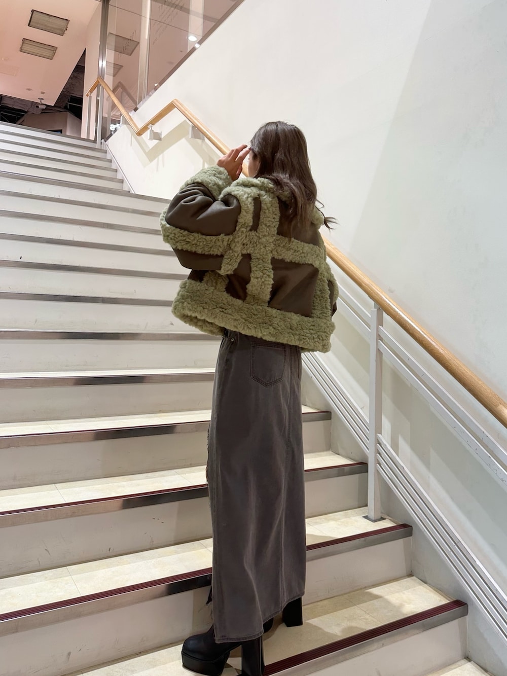 ブラック系のニット/セーター、ブラック系のデニムスカート、ブラック系のブーツを着用したレディースの夏コーディネートの2枚目の写真