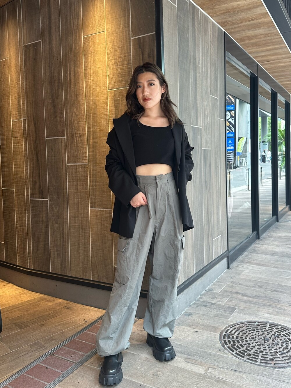 グレー系のカーゴパンツ、ブラック系のTシャツ/カットソー、ブラック系のブーツを着用したレディースの秋コーディネートの3枚目の写真