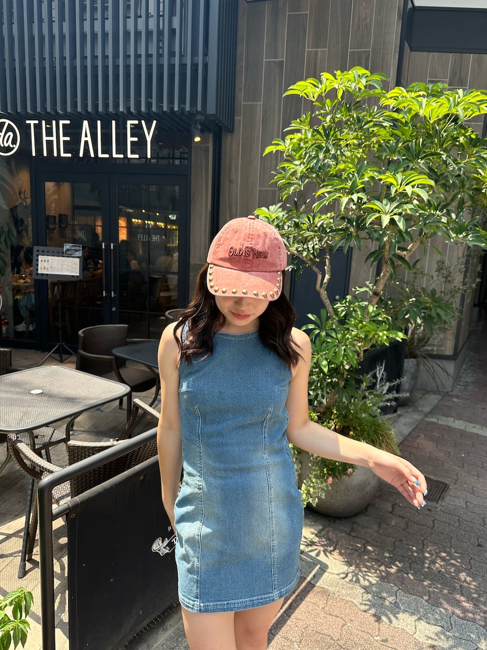 ブルー系のワンピース、ブラック系のサンダル、レッド系のキャップを着用したレディースの夏コーディネートの5枚目の写真