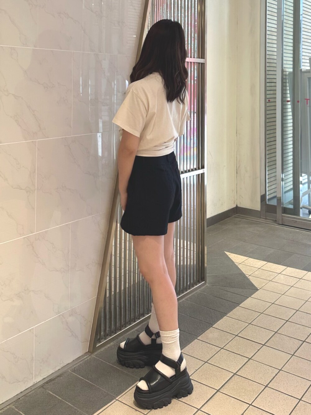 ブラック系のサンダル、ブラック系のその他パンツ、ホワイト系のTシャツ/カットソーを着用したレディースの夏コーディネートの2枚目の写真