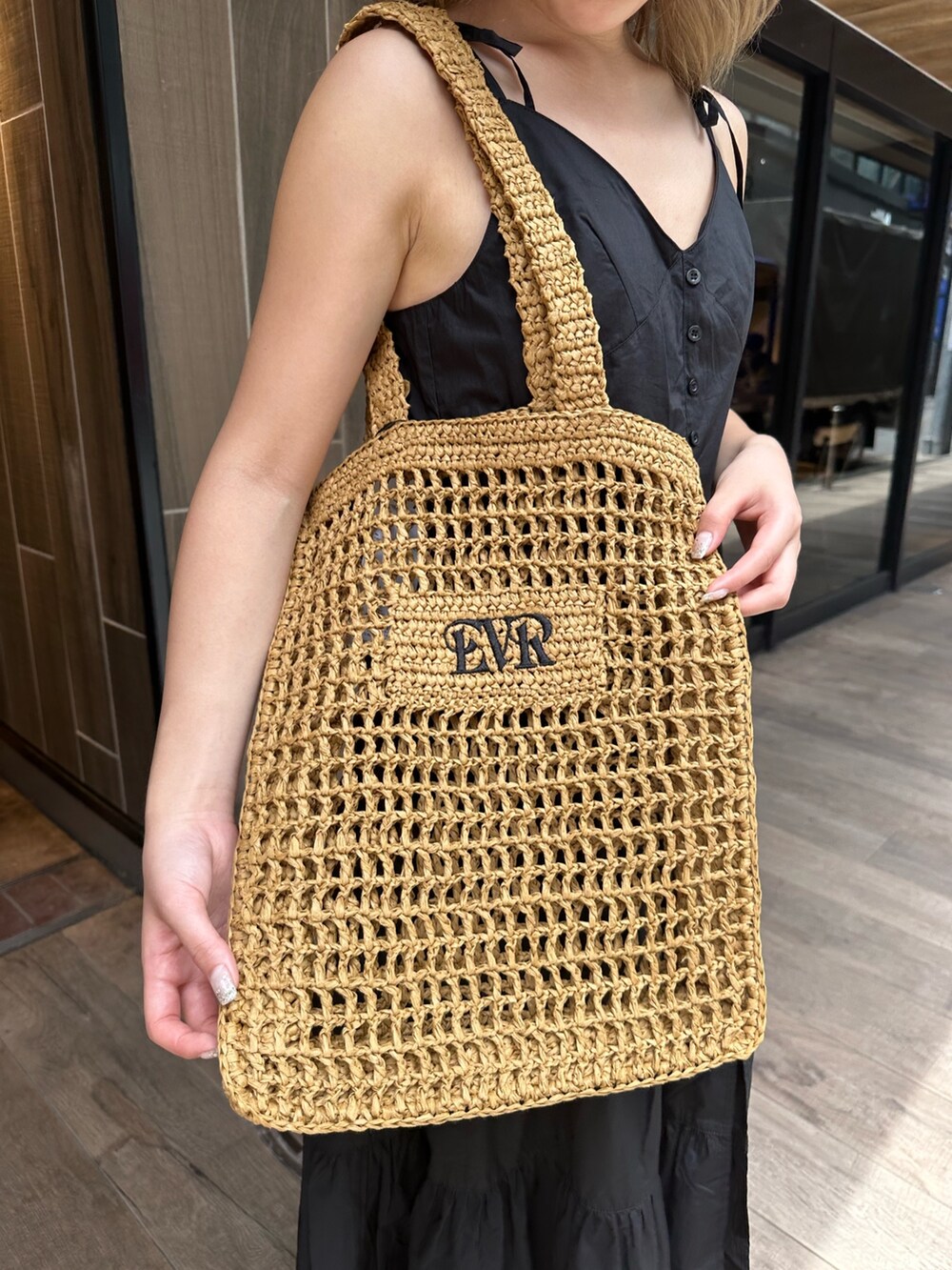 ブラック系のワンピース、ブラック系のサンダル、ベージュ系のトートバッグを着用したレディースの夏コーディネートの8枚目の写真