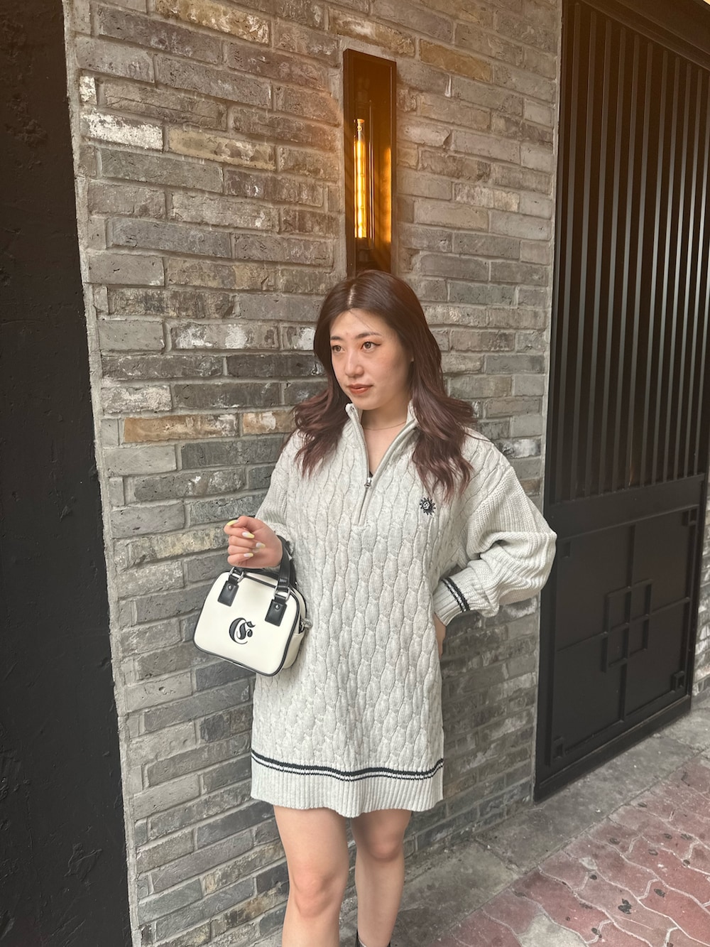グレー系のニット/セーター、ホワイト系のショルダーバッグを着用したレディースの夏コーディネートの4枚目の写真