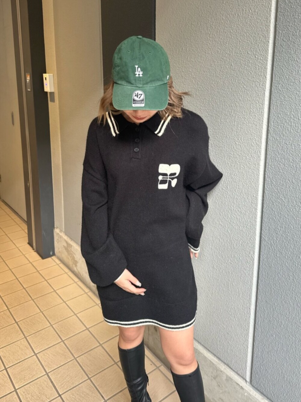 ブラック系のブーツ、ブルー系のデニムスカート、ブラック系のニット/セーターを着用したレディースの冬コーディネートの5枚目の写真