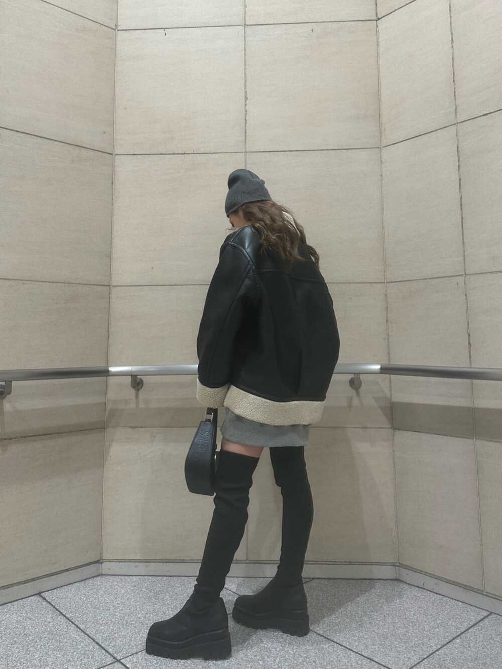 グレー系のスウェット、ブラック系のブルゾン、ブラック系のハンドバッグを着用したレディースの冬コーディネートの3枚目の写真