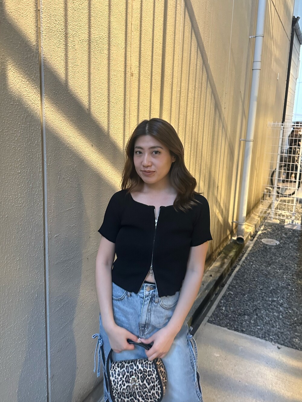 ブルー系のデニムスカート、その他のハンドバッグ、ブラック系のブーツを着用したレディースの春コーディネートの4枚目の写真