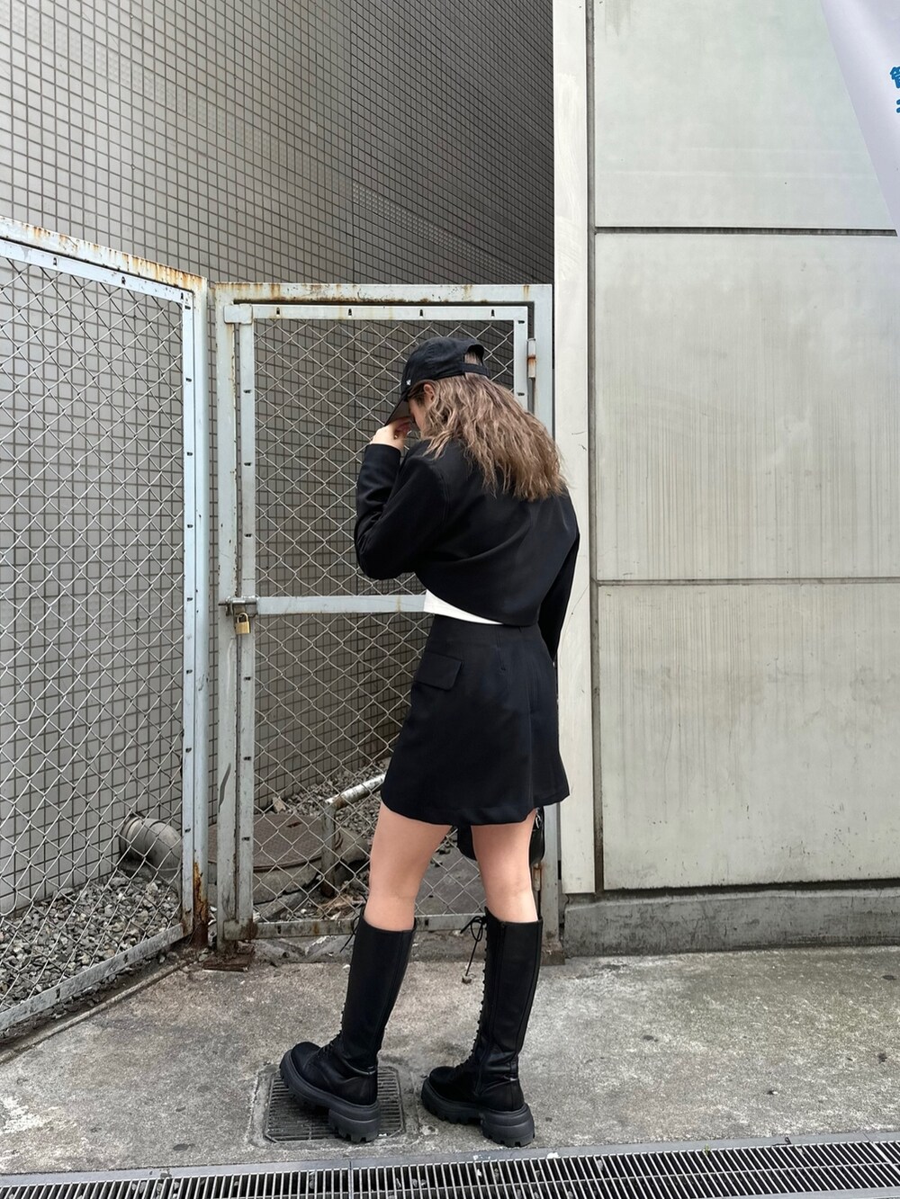 ホワイト系のTシャツ/カットソー、ブラック系のテーラードジャケット、ブラック系のスカートを着用したレディースの春コーディネートの3枚目の写真