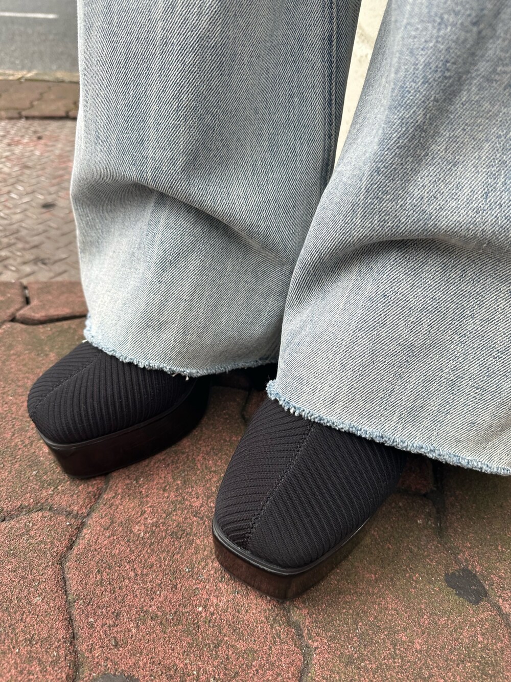 ブラック系のハンドバッグ、ブルー系のデニムパンツ、その他のブーツを着用したレディースの秋コーディネートの8枚目の写真