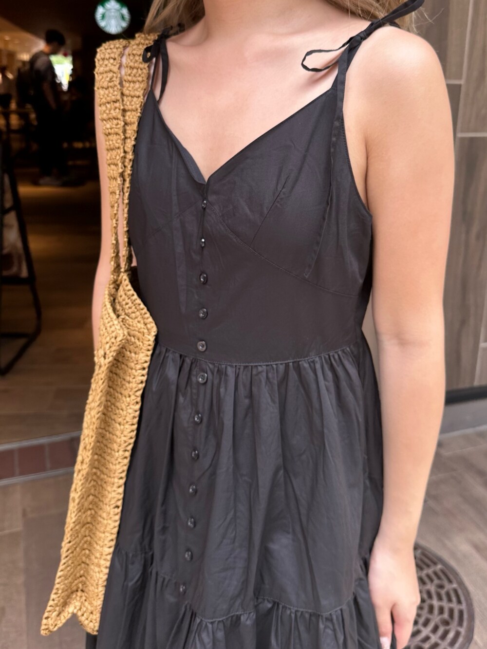 ブラック系のワンピース、ブラック系のサンダル、ベージュ系のトートバッグを着用したレディースの夏コーディネートの6枚目の写真