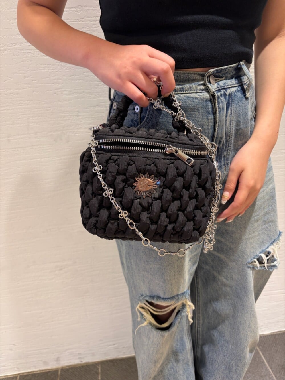 ブルー系のデニムパンツ、ブラック系のショルダーバッグ、シルバー系のサンダルを着用したレディースの夏コーディネートの7枚目の写真